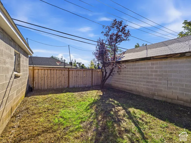 Exterior side yard featuring concrete block walls and vertical wood privacy fencing