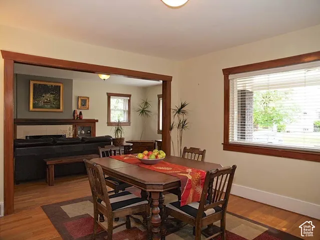Dining space featuring original natural wood trim, wood flooring, and a wide cased opening