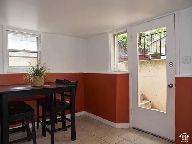 Ceramic tile flooring, white-painted walls with two-tone wall color treatment, single-hung window, and glass-paneled exterior door