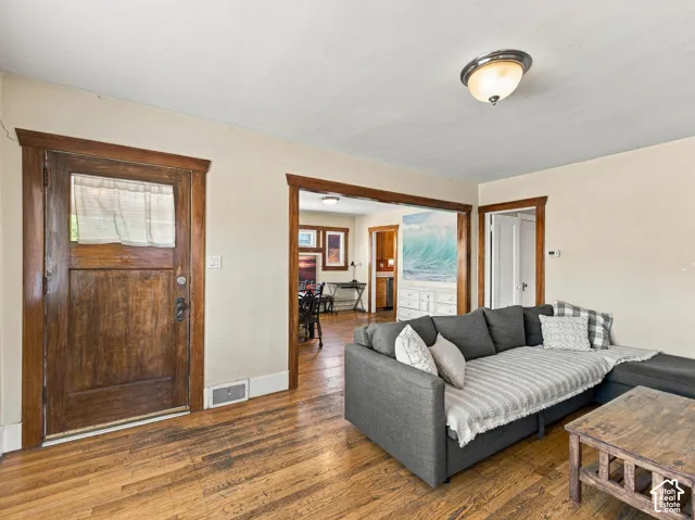 Interior entry featuring original wood-finish flooring, stained wood door casing, and matching wide-width door trim throughout