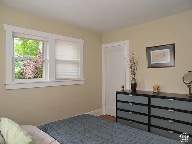 Neutral interior space featuring crisp white window casing, a classic paneled door with brass hardware, and a double-hung window