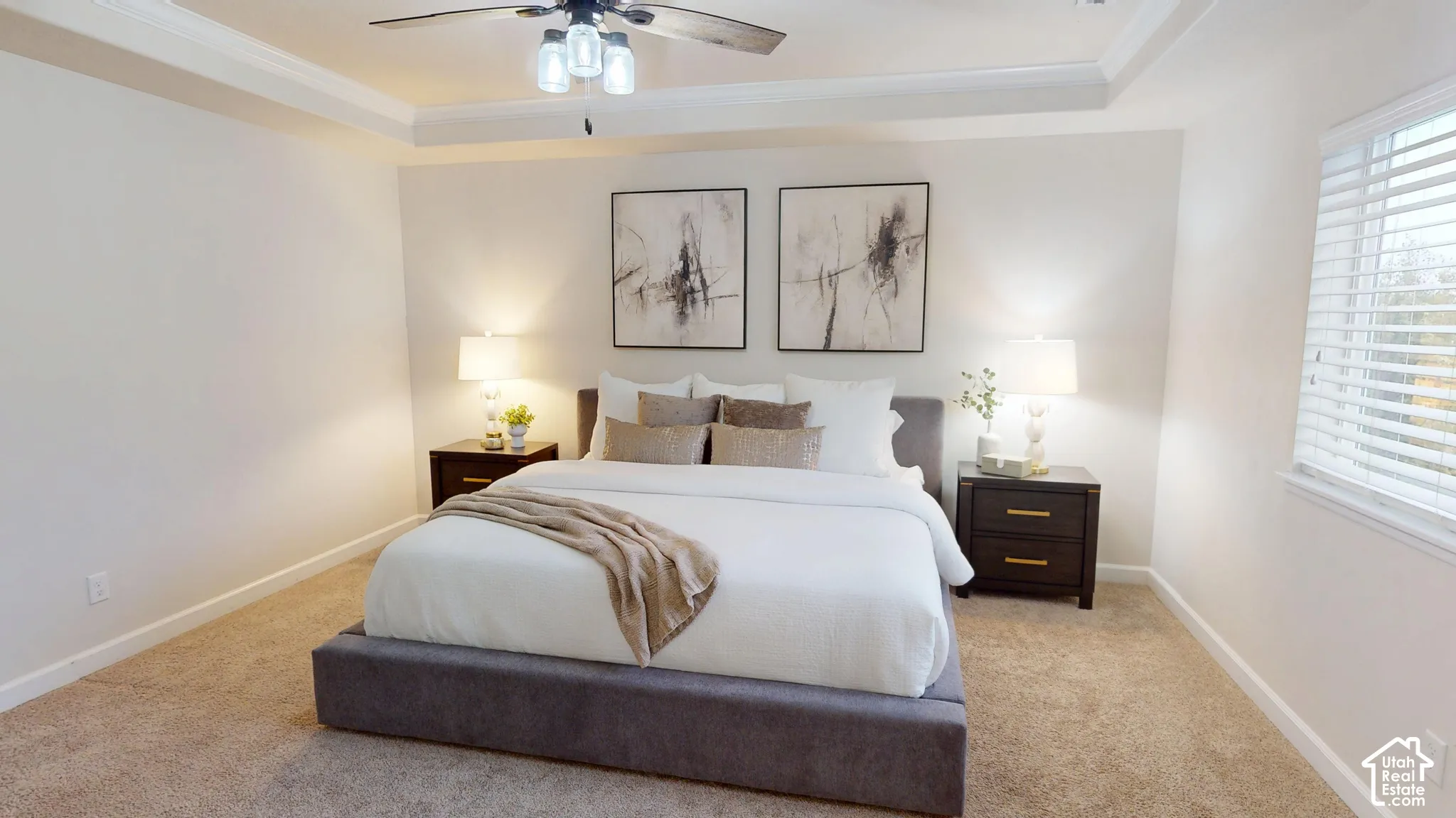 Bedroom featuring a tray ceiling, ceiling fan with glass pendant lights, and neutral wall paint
