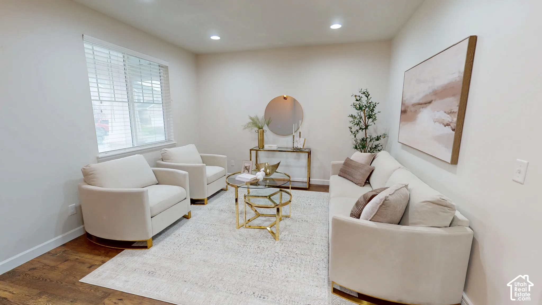 Neutral-toned sitting room featuring recessed lighting, wood-finish flooring, and a large window with fitted blinds