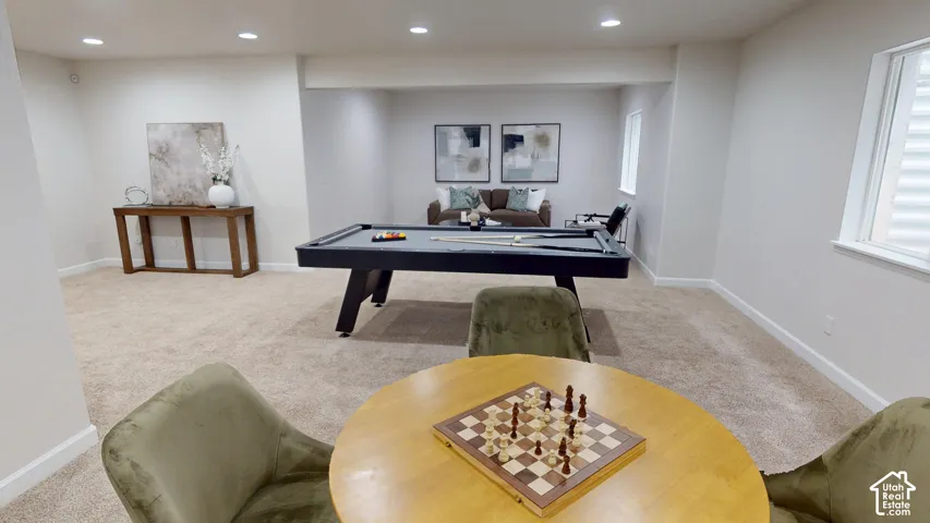 Neutral-toned interior space featuring recessed ceiling lighting, wall-to-wall carpeting, and multiple windows