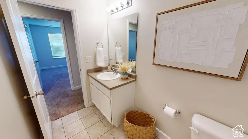 Upstairs full bathroom featuring a white vanity cabinet, a solid-surface countertop with an integrated oval sink, a large wall-mounted mirror, ceramic tile flooring, and chrome-finish hardware