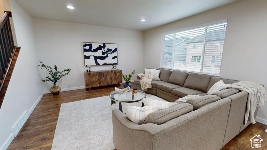 Living area featuring wood-finish flooring, recessed lighting, and a large window