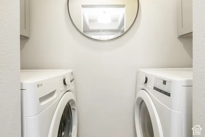 Built-in upper cabinetry, circular wall-mounted mirror, and neutral wall finish