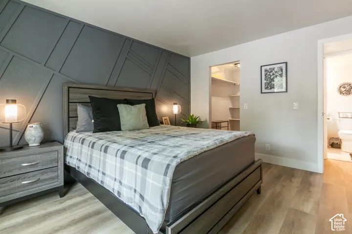 Geometric wall molding, wood-finish flooring, and built-in closet shelving