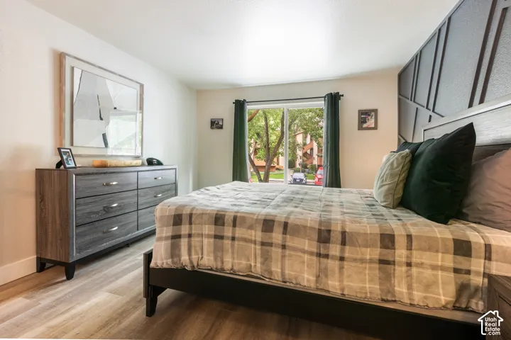 Room featuring wood-finish flooring, a decorative geometric wall accent, and a picture window