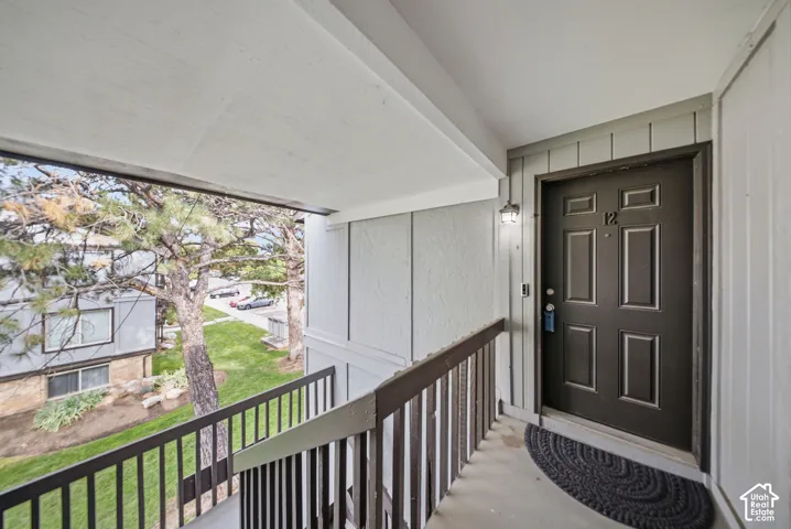 Covered entryway with panel door and wall sconce lighting