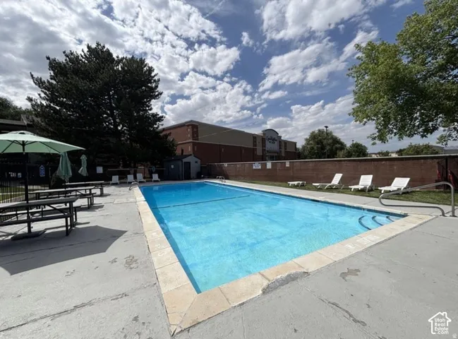 Outdoor swimming pool with concrete decking, surrounded by a brick privacy wall