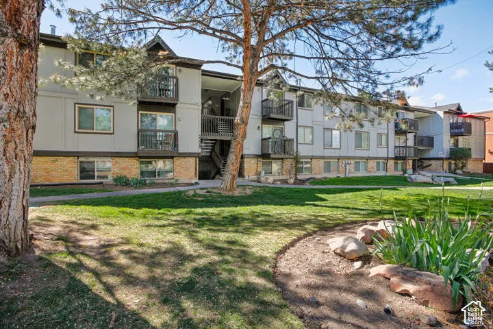 Exterior building featuring light gray siding with brick accents 3rd floor unit