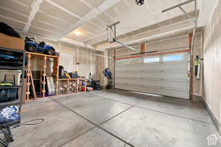 Attached two-car garage featuring a sectional door, concrete flooring, and an automated garage door opener