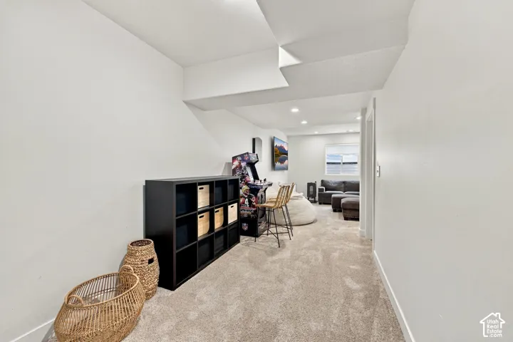 Neutral-toned wall-to-wall carpeting, recessed ceiling lighting, and a window with natural light