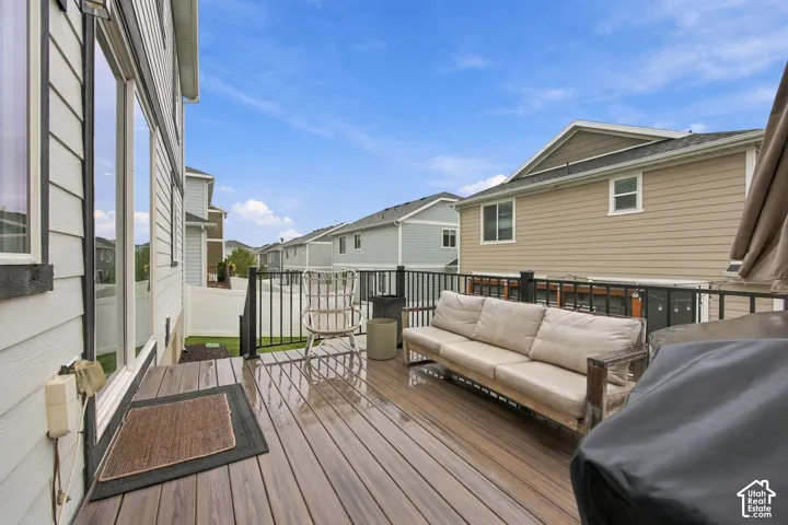 Raised deck featuring composite decking material, horizontal metal balustrades, and horizontal siding exterior