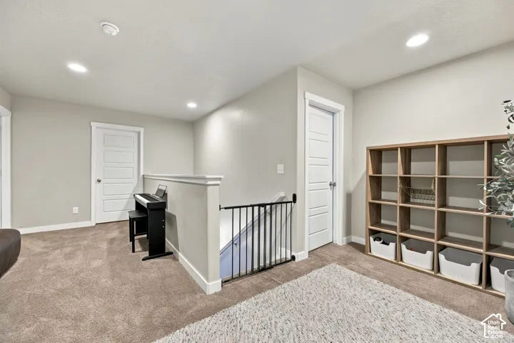 Neutral-toned interior space featuring recessed ceiling lighting, wall-to-wall carpeting, and solid-core interior doors