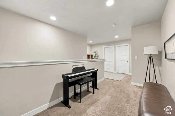 Neutral carpeting, recessed lighting, and white interior doors with five-panel detailing