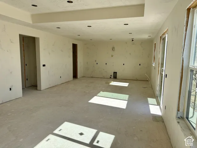 Open floor plan featuring recessed lighting, tray ceiling, and sliding glass door