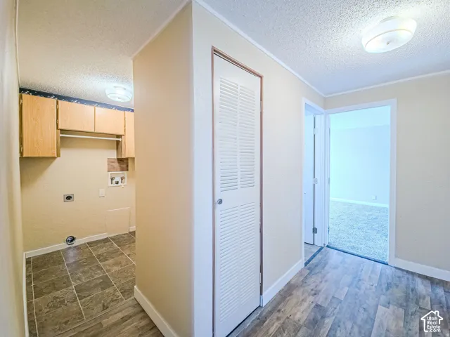 Utility space featuring square tile flooring, built-in overhead cabinetry, and integrated louvered-door closet