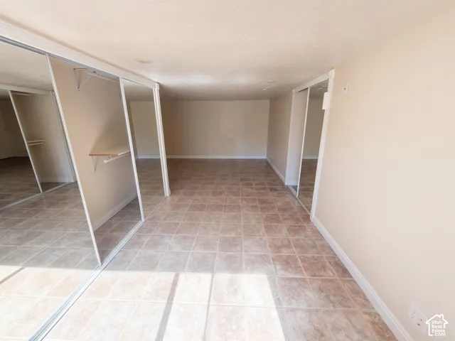 Interior space featuring ceramic tile flooring, mirrored sliding closet doors, and recessed lighting