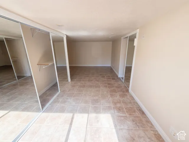 Tile flooring, dual mirrored sliding closet doors, and built-in closet shelving