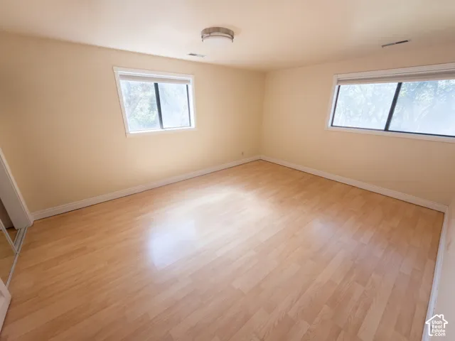 Interior space featuring wood-finish flooring, two large windows, and a flush-mount circular ceiling fixture