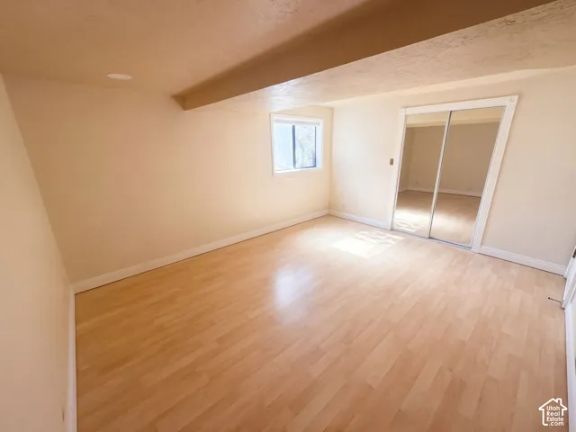 Neutral wall tones, wood-finish flooring, and sliding mirrored closet doors