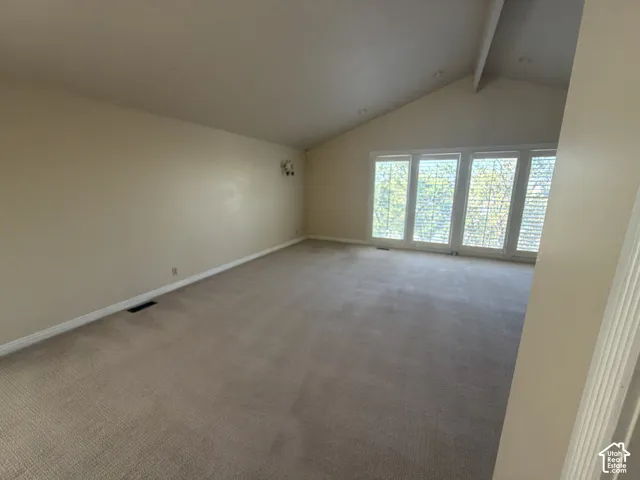 Vaulted ceiling, wall-to-wall carpeting, and a four-panel window configuration with louvered shutters