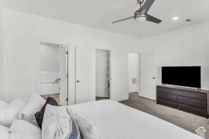 Neutral-toned carpeting, ceiling fan with integrated lighting, recessed ceiling lights, and multiple interior doors with flat-panel detailing