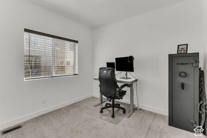 Neutral-toned carpet flooring, crisp white walls, and a window with horizontal blinds