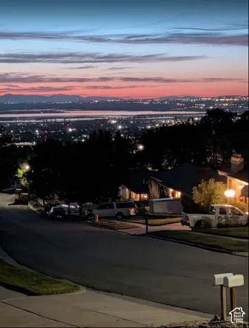 Elevated neighborhood setting featuring expansive terrain, mountain topography, and city-light scenery