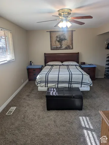 Room featuring neutral wall tones, carpeted flooring, a ceiling fan with integrated lighting, and horizontal slatted window blinds