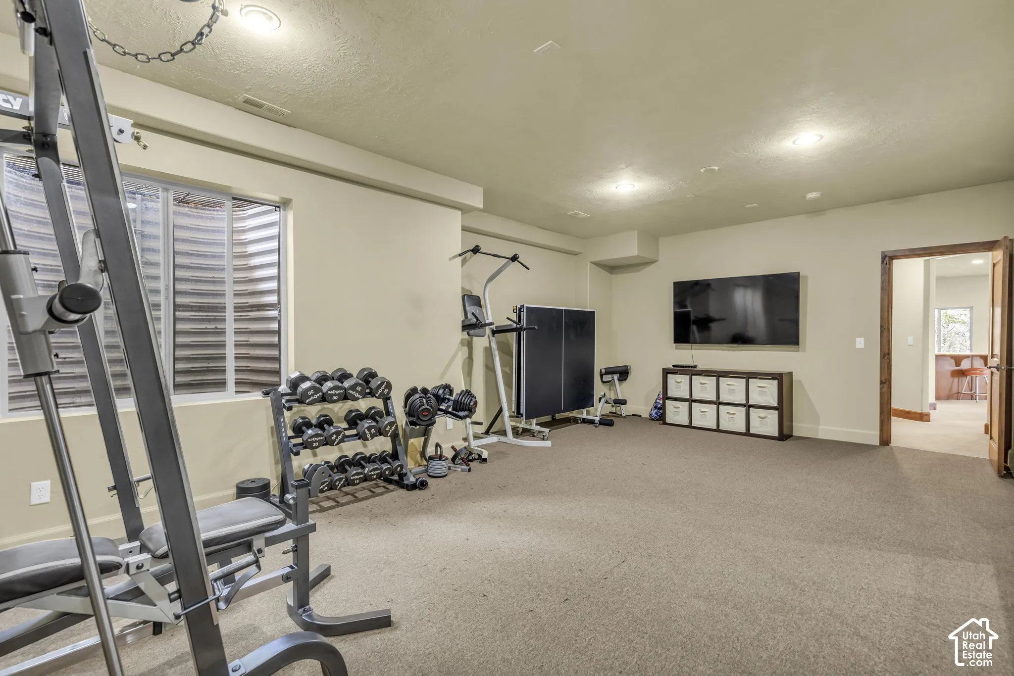 Spacious room with plush carpeting, recessed lighting, and a large egress window