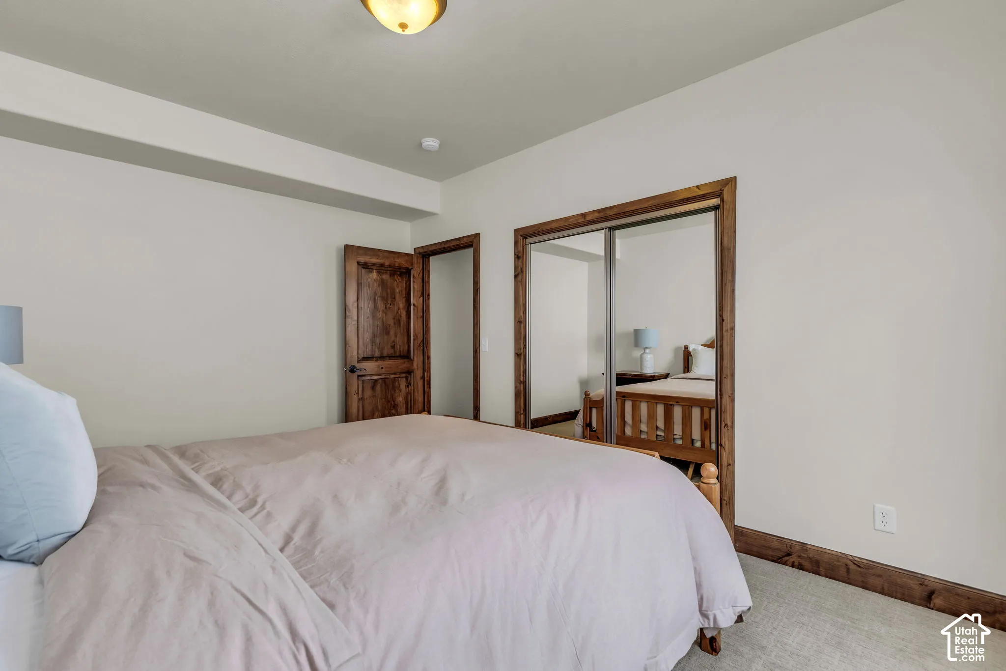 Recessed ceiling, wood-finish door, wood-finish trim, mirrored sliding closet doors, and carpet flooring