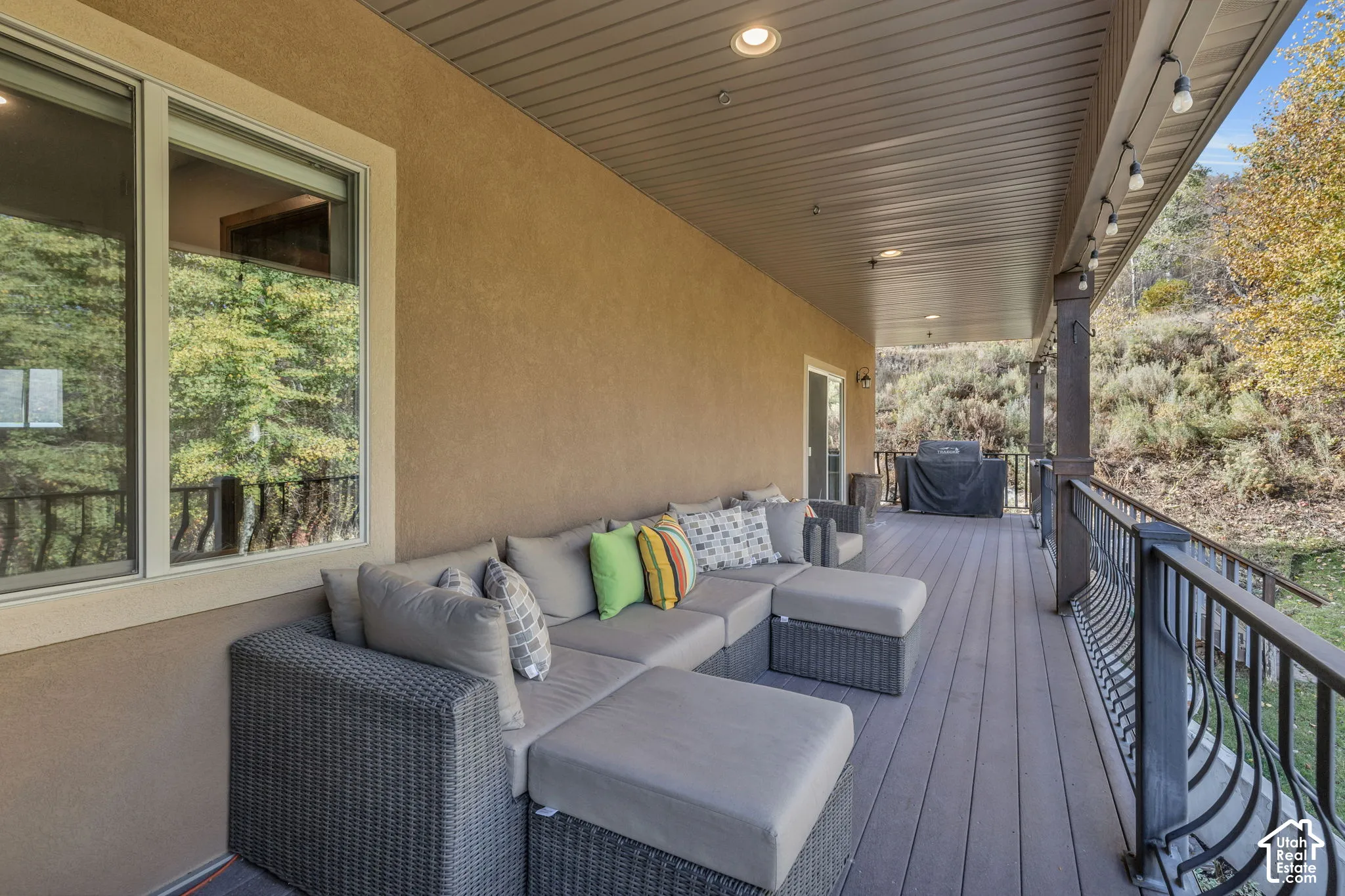 Spacious covered deck featuring a textured ceiling, recessed lighting, and a durable composite deck surface