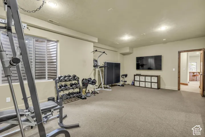 Spacious room with plush carpeting, recessed lighting, and a large egress window