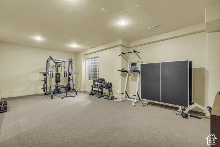 Carpeted room with recessed lighting and a window with horizontal blinds