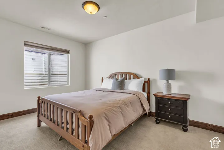 Carpeted flooring with wood-finish trim, window with blinds, and flush-mount ceiling light
