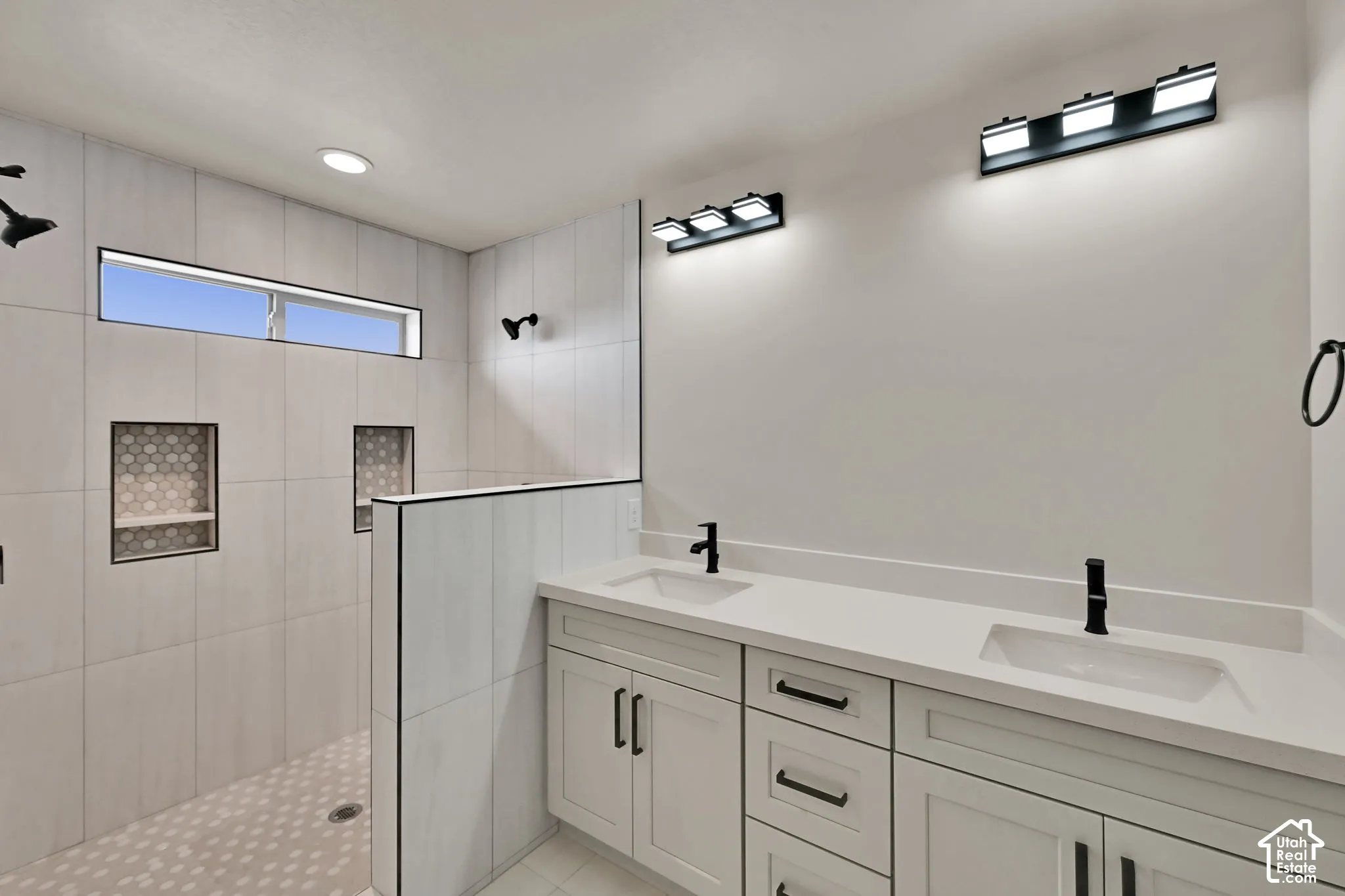 Dual vanity featuring white shaker-style cabinetry, quartz countertops, and matte black hardware