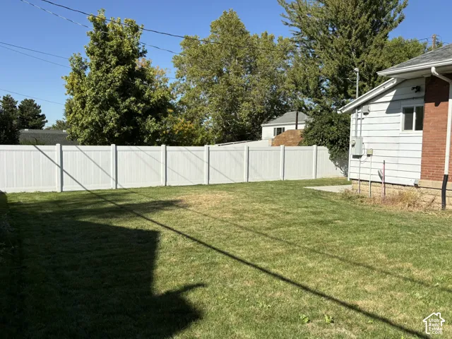 Expansive grassy yard with a full privacy fence