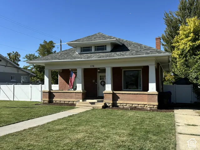 Brick exterior with a covered front porch featuring white columns