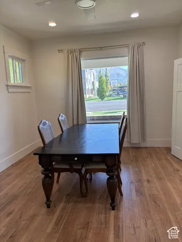 Wood-finish flooring, recessed lighting, ceiling fan, and large windows with mountain scenery