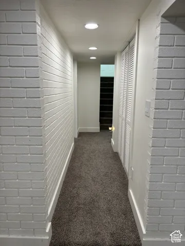 Recessed lighting, painted brick wall, carpeted flooring, louvered bi-fold doors