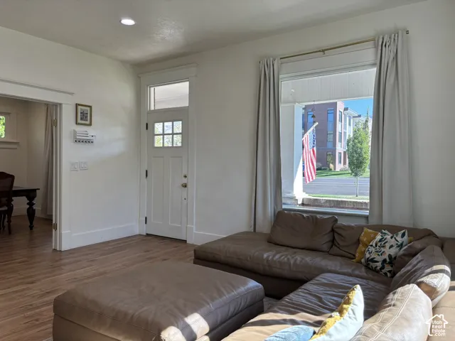 Wood-finish flooring throughout, white trim and baseboards, recessed ceiling lighting, and a window with a transom