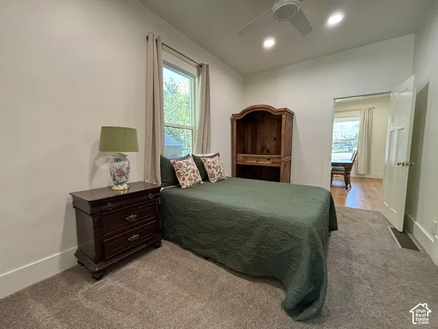 Recessed lighting, ceiling fan, window with window treatment, neutral wall color, and carpeted flooring