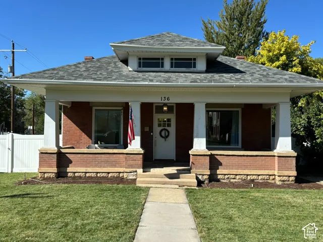Brick exterior with a covered front porch, supported by four columns