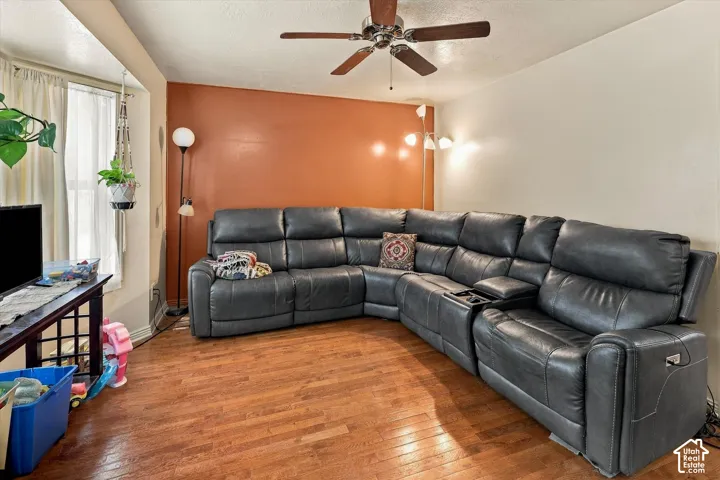 Wood-finish flooring, ceiling fan with light kit, and bay window