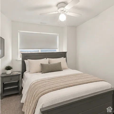 Neutral-toned interior space featuring a ceiling fan with integrated lighting, wall-to-wall carpeting, and a roller shade window treatment