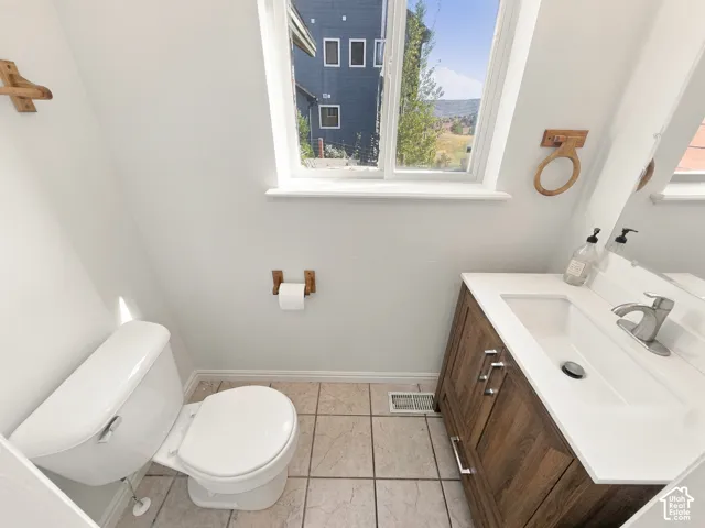 Vanity featuring a dark wood-finish cabinet, white solid-surface countertop, and integrated sink