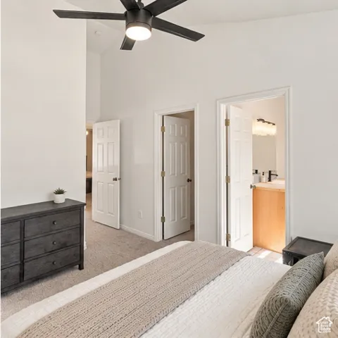 Vaulted ceilings featuring a matte black finish ceiling fan with integrated lighting and wall-to-wall carpeting